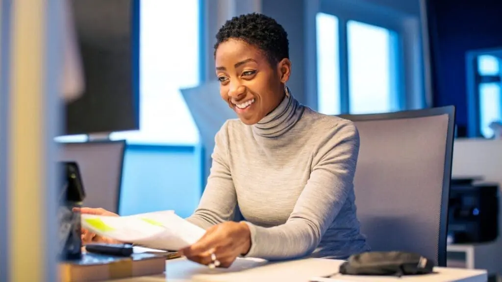 Woman Smiling at a Computer while working